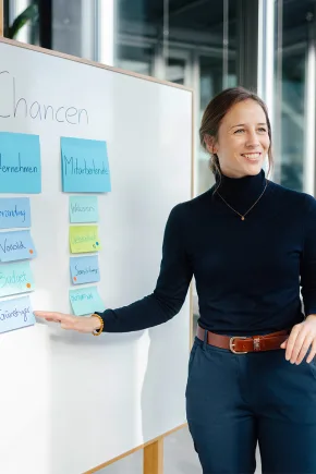 A woman explains several terms on a board about climate protection.