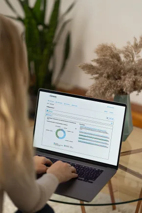 Eine Frau sitzt vor einem Computer und schaut sich verschiedene Grafiken und Diagramme an.
