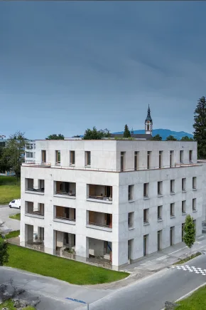 Ein modernes mehrstöckiges Gebäude steht an einer Straßenecke.