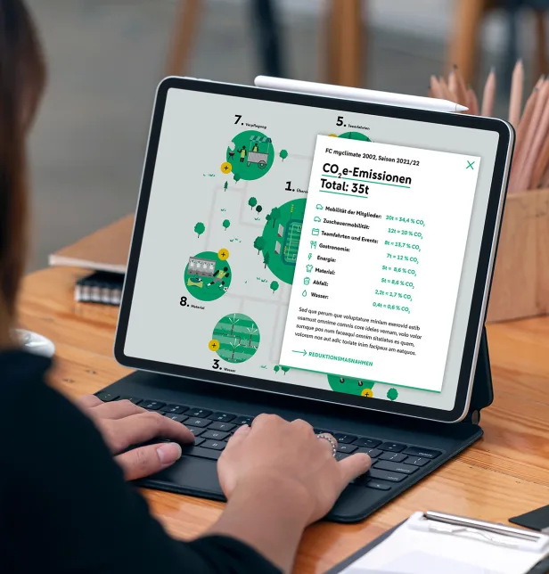 Eine Person arbeitet an einem Laptop, auf dessen Bildschirm eine digitale Übersicht zu CO₂‑Emissionen angezeigt wird.
